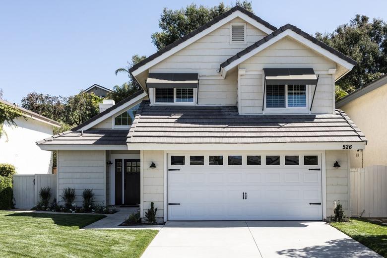 A traditional white house with gray roofing.