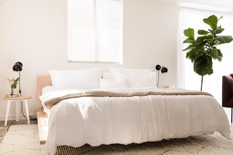 a platform bed made from birch plywood panels with white bedding