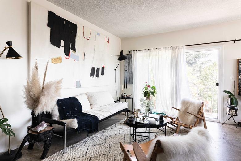 Sheer curtains over sliding glass doors in a living room with abstract art and modern furniture