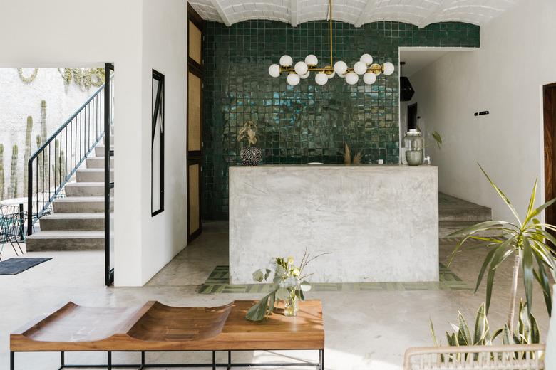 entry room with wooden table, concrete floor, scalloped ceilings, open to outdoors