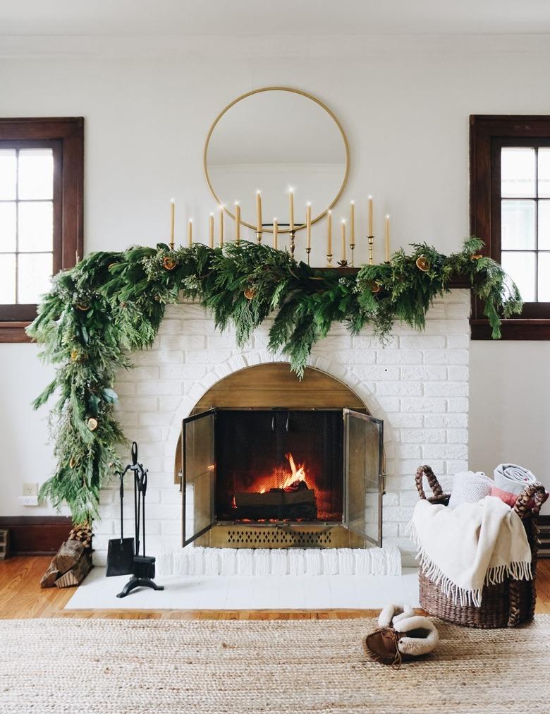 DIY Christmas decorations for white fireplace with mirror above and garland on the mantel