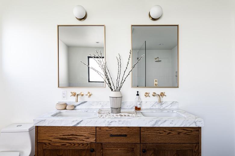 White bathroom with a wood twin sink vanity unit with a marble countertop