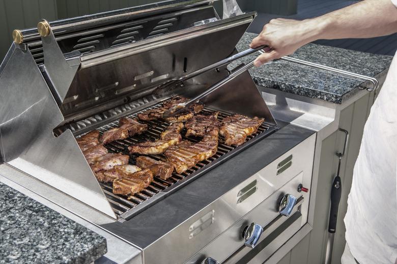 outdoor propane gas grill with man turning stakes