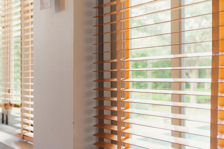 Window blind letting in light from sun, home interior concept