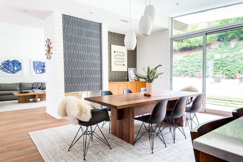 Midcentury modern style dining room with black Eames chairs and tile accent wall