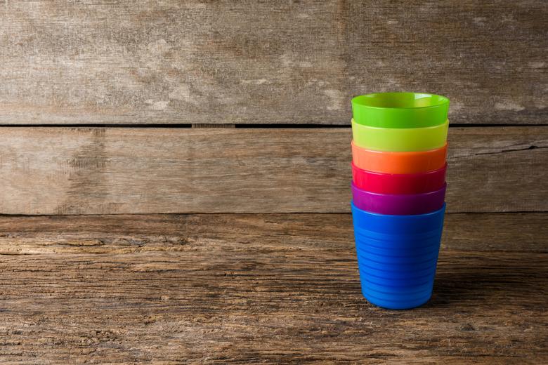 Colorful plastic glass on wooden background