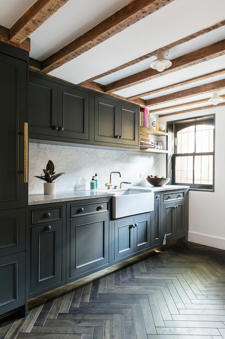 basement kitchen with exposed beams and dark cabinets