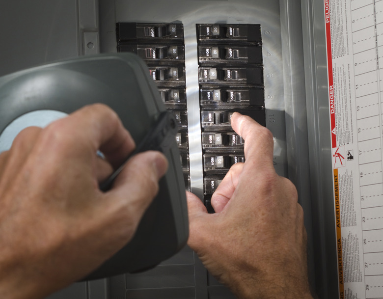 man with flashlight at residential circuit breaker panel