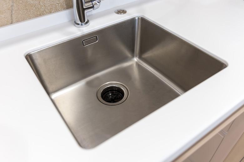 Stainless kitchen sink with food waste disposal in modern home