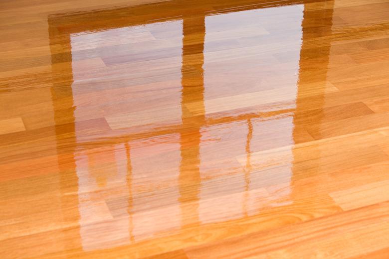 Wet polyurethane on new hardwood floor with window reflection.