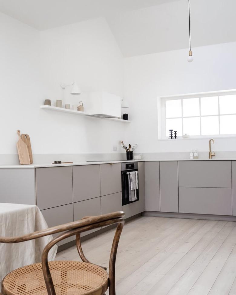 Modern cookspace with gray flat panel kitchen cabinets and simple decor