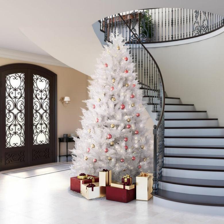 White Christmas Tree Ideas with White artificial Christmas tree, red and gold ball ornaments, sloped staircase, double entry doors, white floors, foyer.