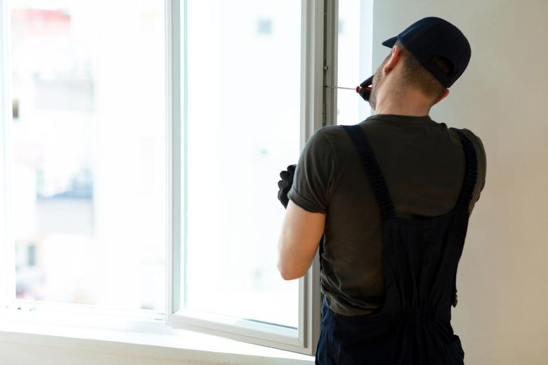 Worker installing new plastic pvc window.