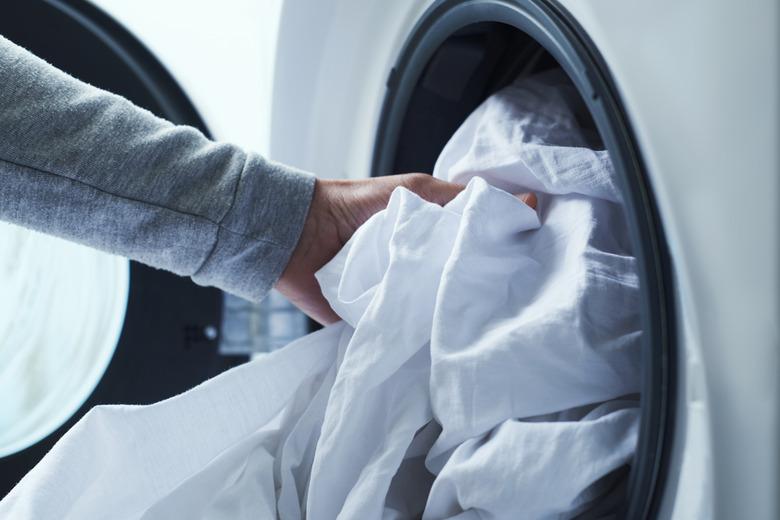 man putting clothes into the washing machine