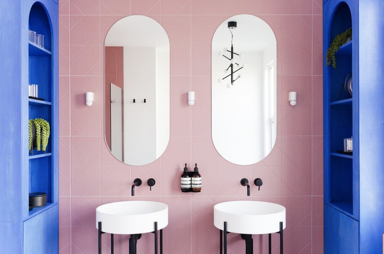 Pink bathroom backsplash with blue shelves