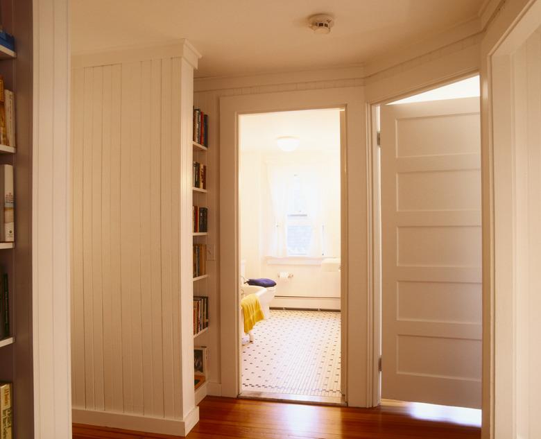 White Beaded Paneling in Hallway Leading to Bathroom