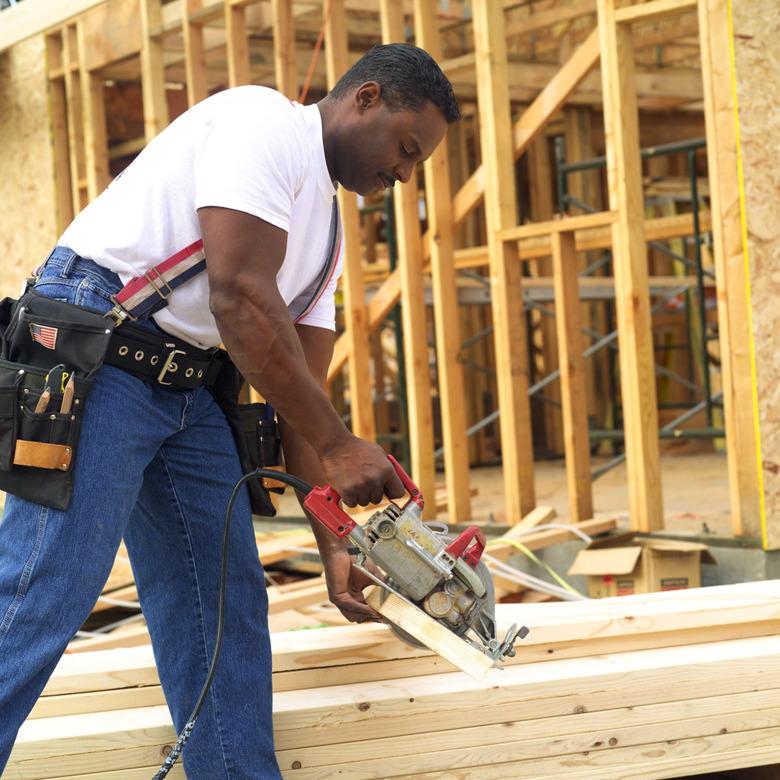 Construction worker cutting lumber