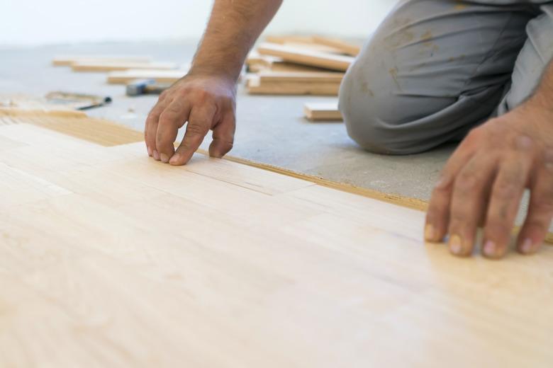 Carpenter lining up parquet-laminate plank