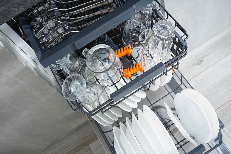 Dishwasher, open and loaded with dishes in the kitchen, after washing. Flat lay.