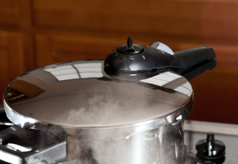 Pressure being released from cooker on hob