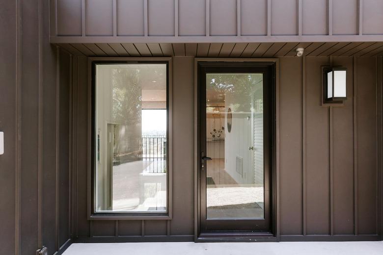 Front entrance of a black house with a casement door and window