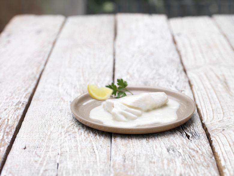 Plate of bake in bag haddock mornay on wooden table