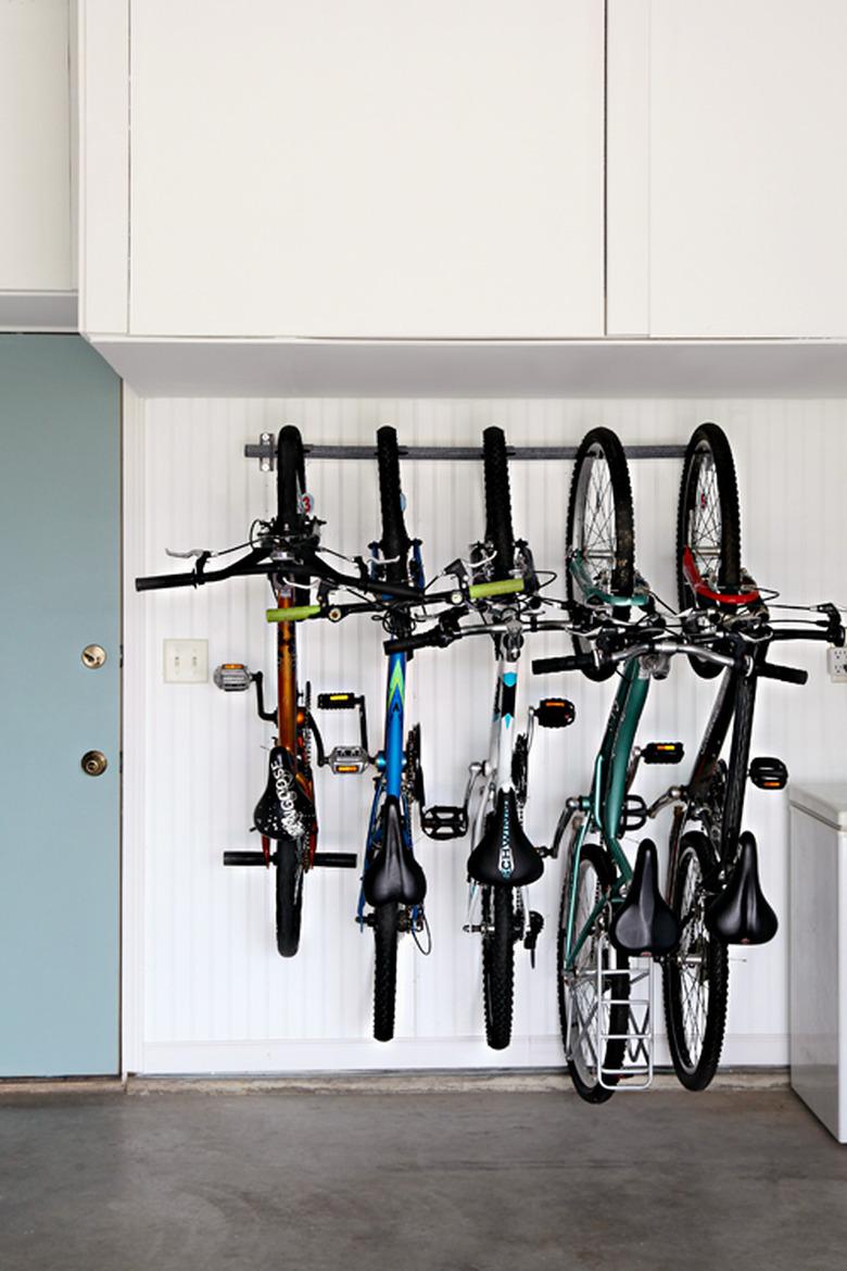 Bike storage using a rack in the garage next to blue door