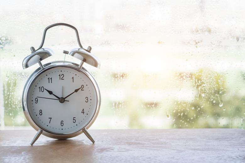 vintage alarm clock and classic design near window on wooden floor.