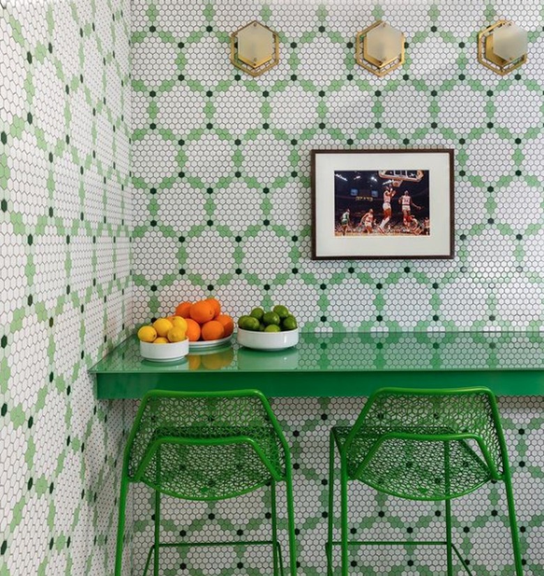 Green and white tiled kitchen with green chairs