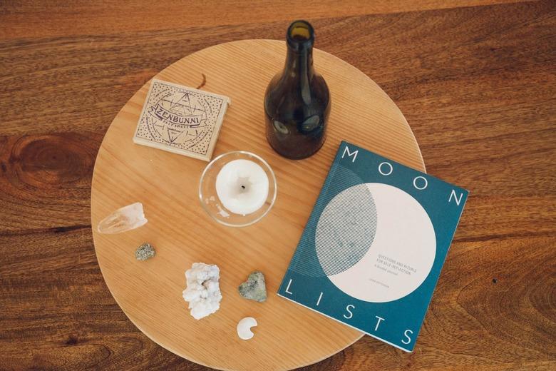 Round wood coffee table with a book titled, 