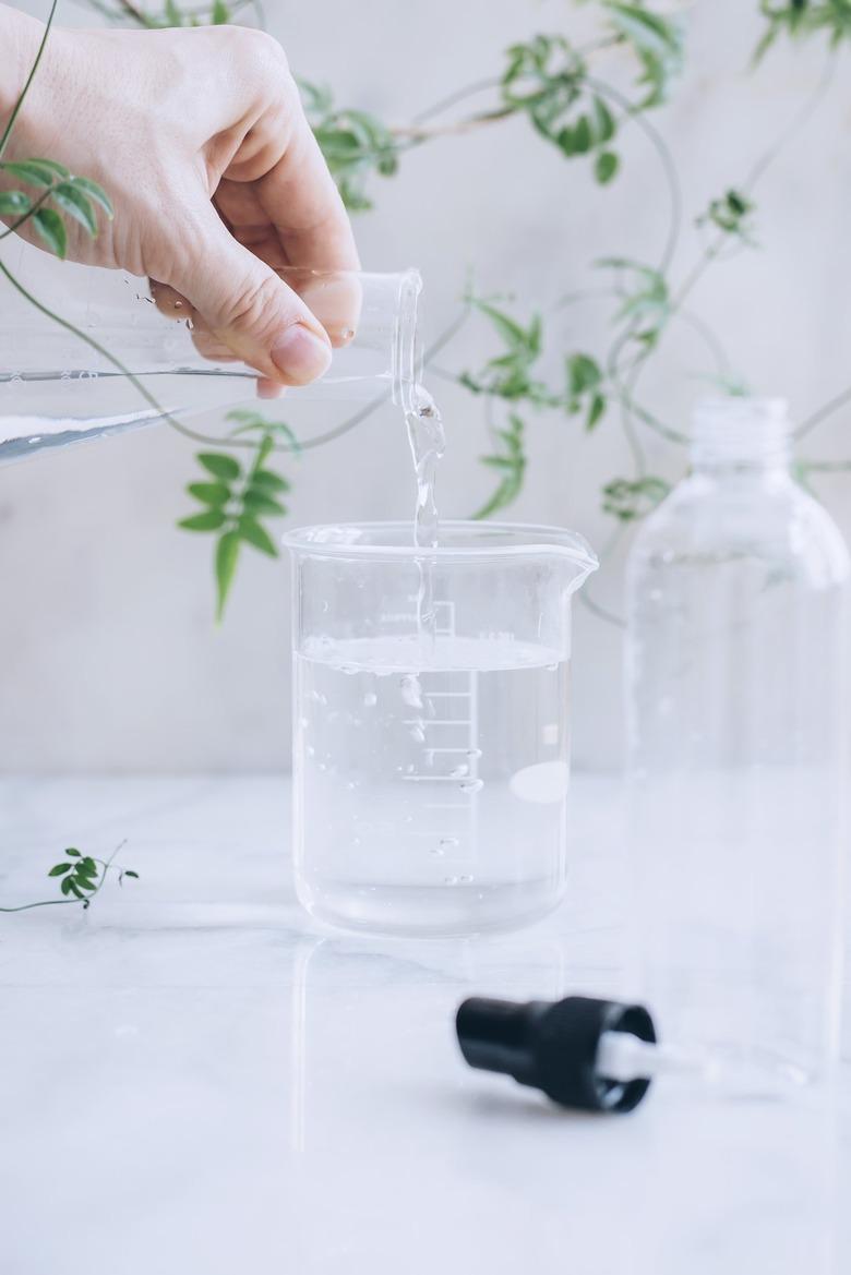 mixing water and rubbing alcohol in a measuring cup