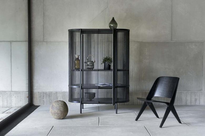 black chair near cabinet and concrete wall