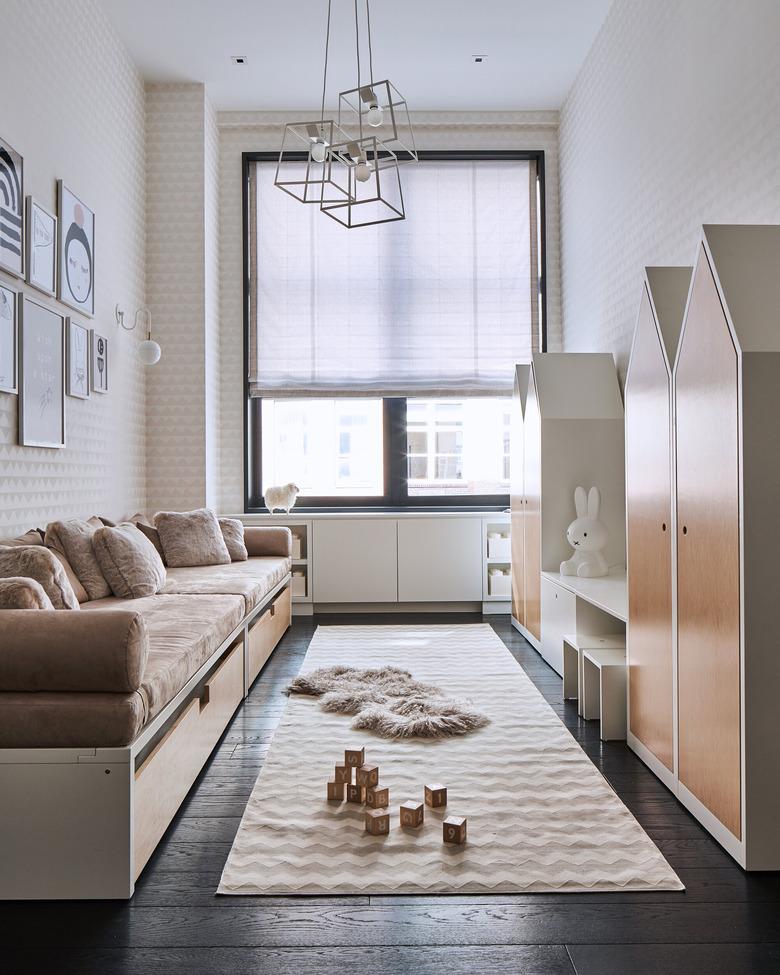 kids playroom idea with fun cabinets for storage and rug on wood flooring