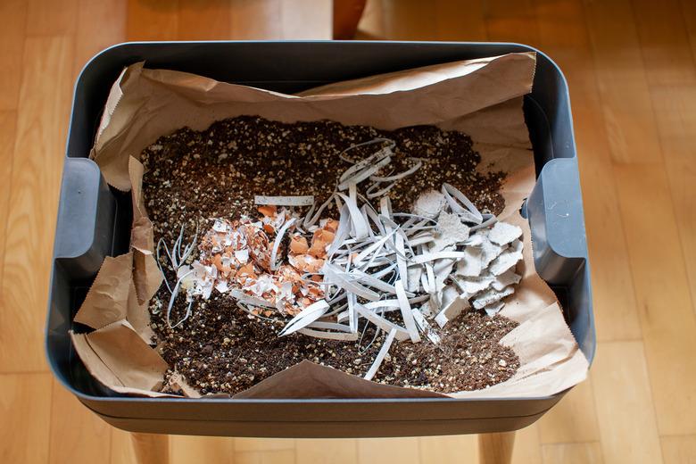 A mixture of bedding material is put into the starting tray of a worm composter