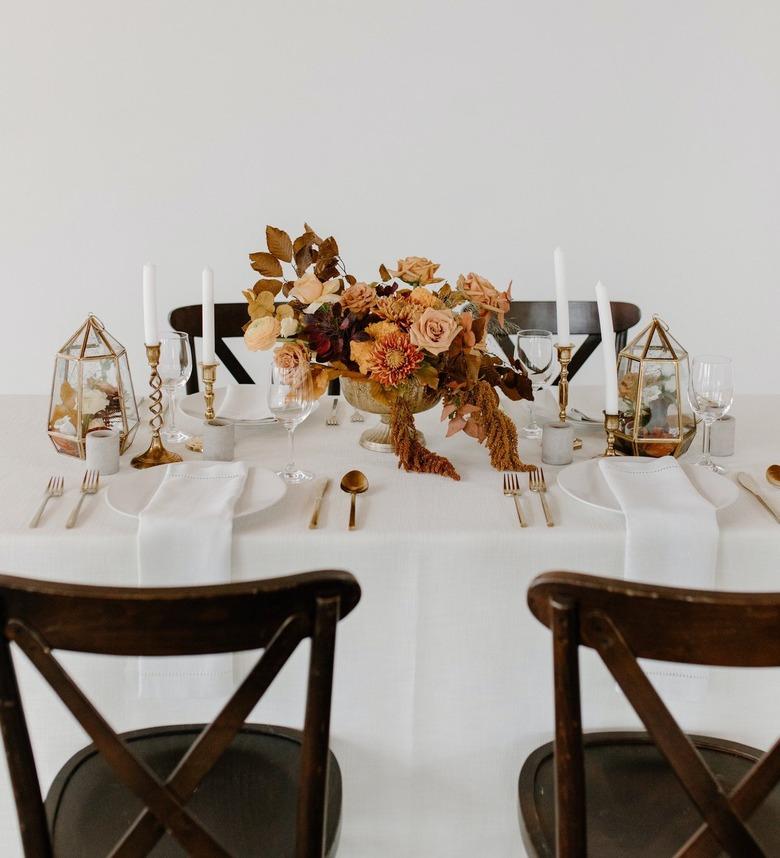 tablescape with dried orange flowers and gold silverware