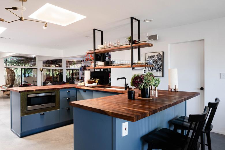 u-shaped kitchen island with wood counterops and navy blue accetns