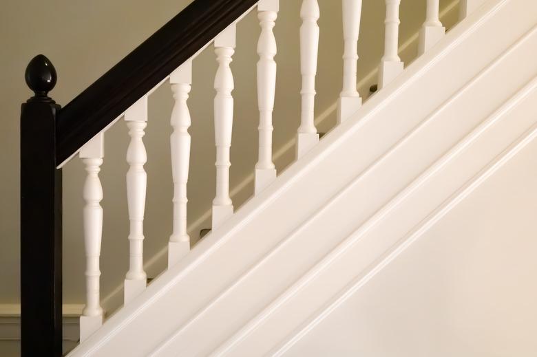 Hand-carved wooden spindles on old-fashioned bannister of early 20th century tudor home staircase.