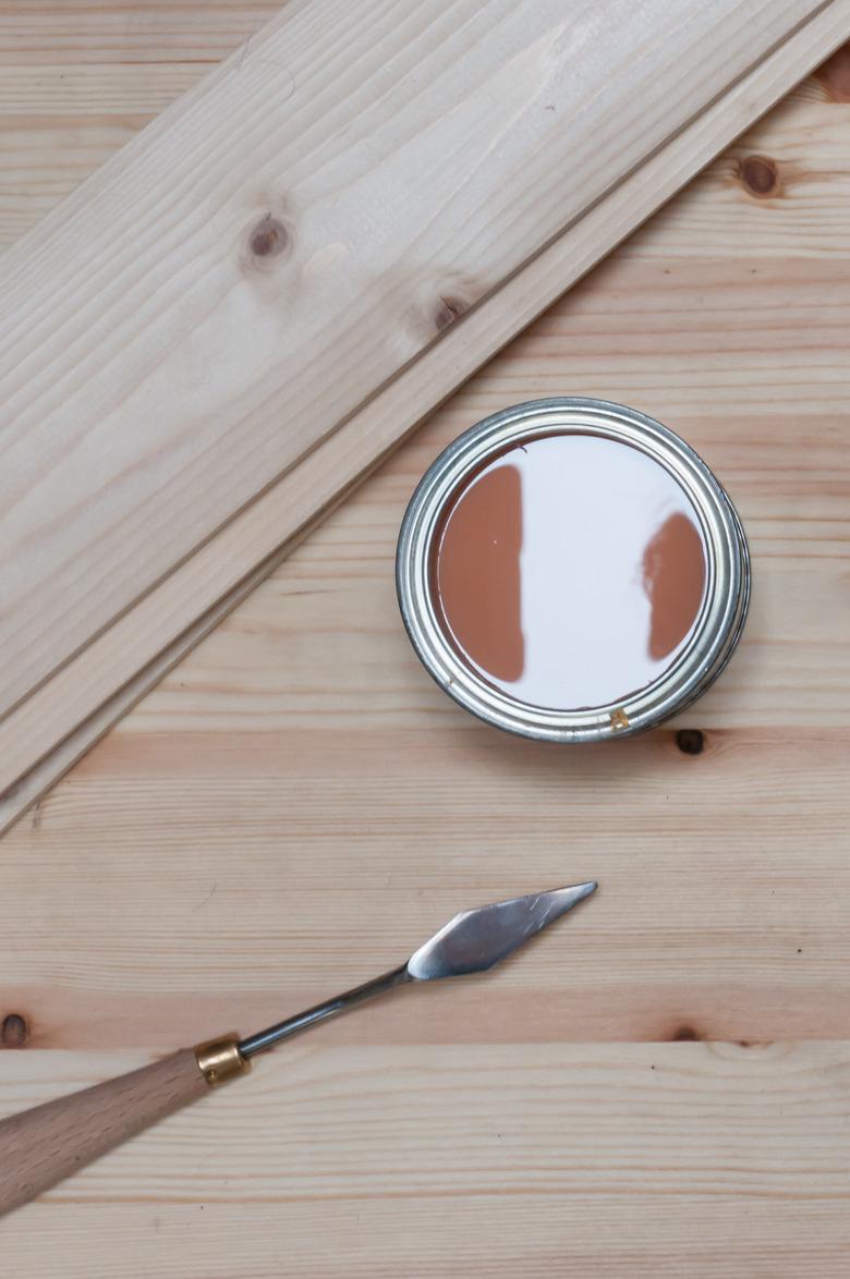 Spatula and wood putty on a wooden table.