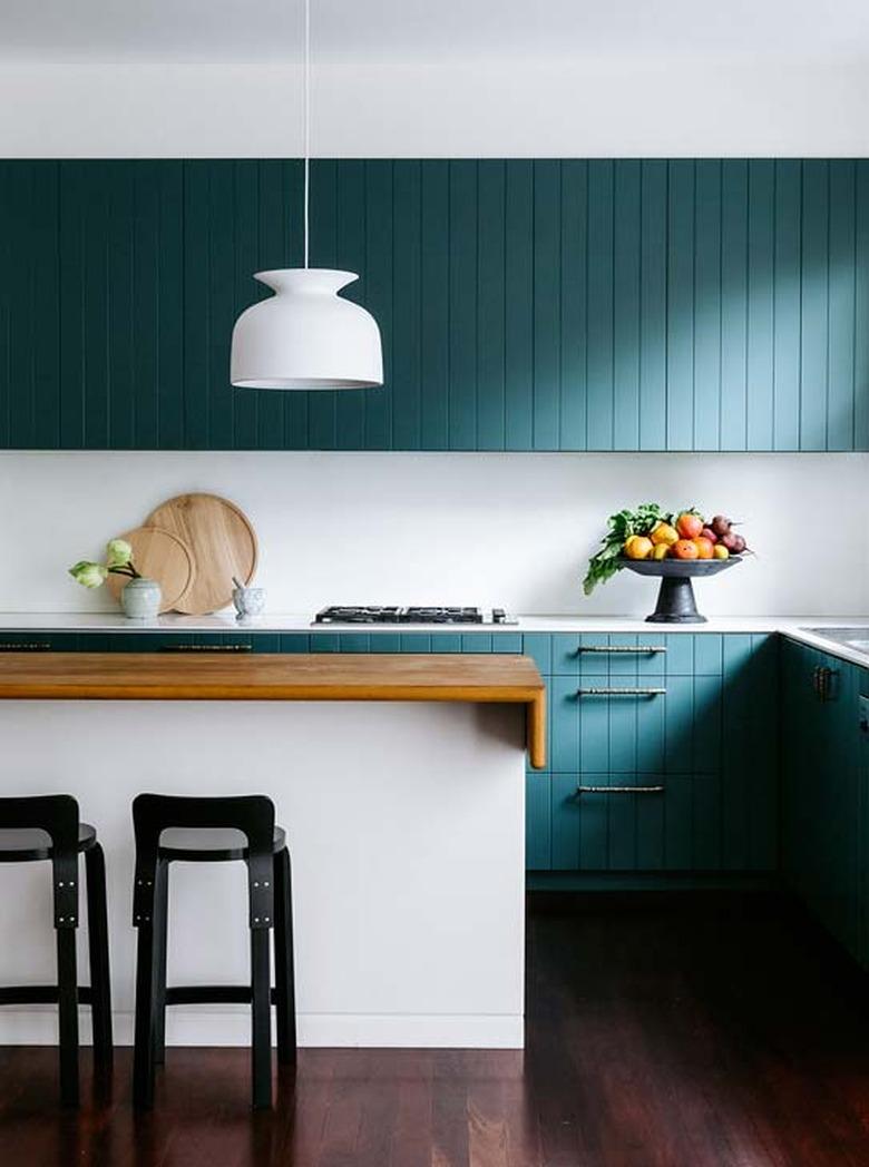 minimalist kitchen with green beadboard cabinets