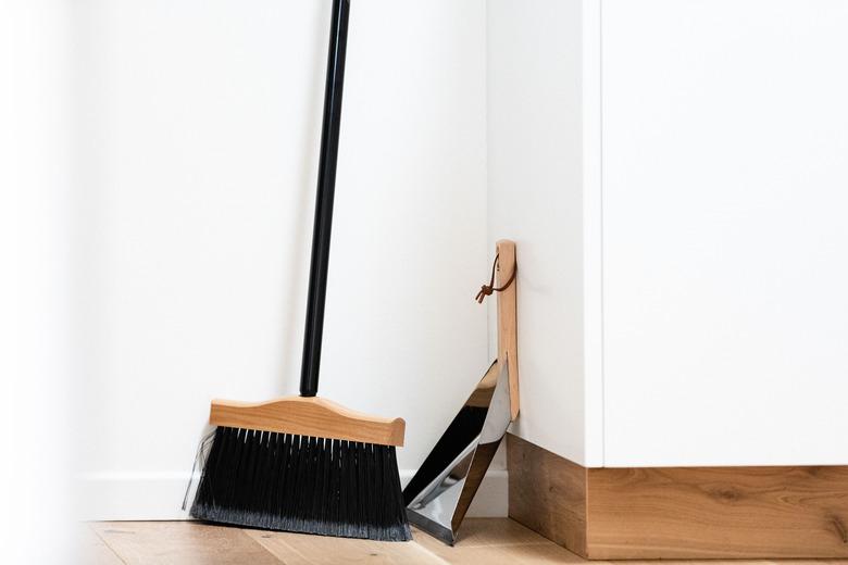 Broom and dust pan on wood floor