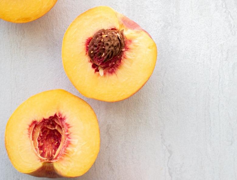 peaches with pits on white background