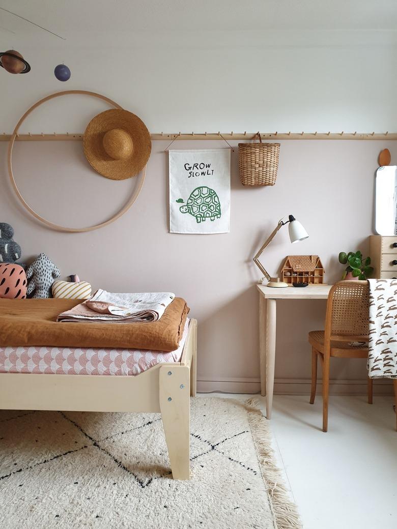 pink and brown minimalist girl bedroom with hula hoop and peg rail