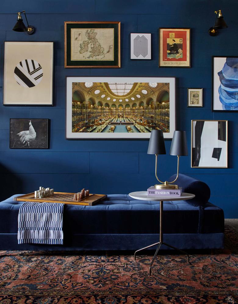 blue living room wall with gallery wall and daybed