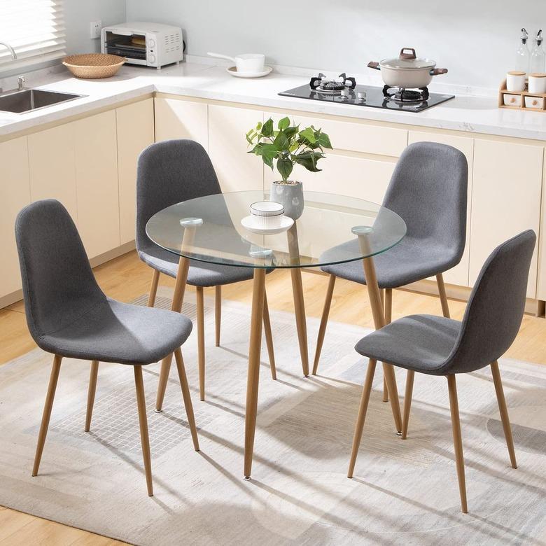 round glass dining table with four gray chairs in a kitchen