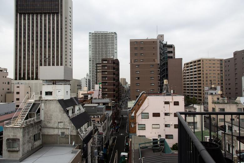 the view from several stories up is of high-rise buildings and tangles of power lines