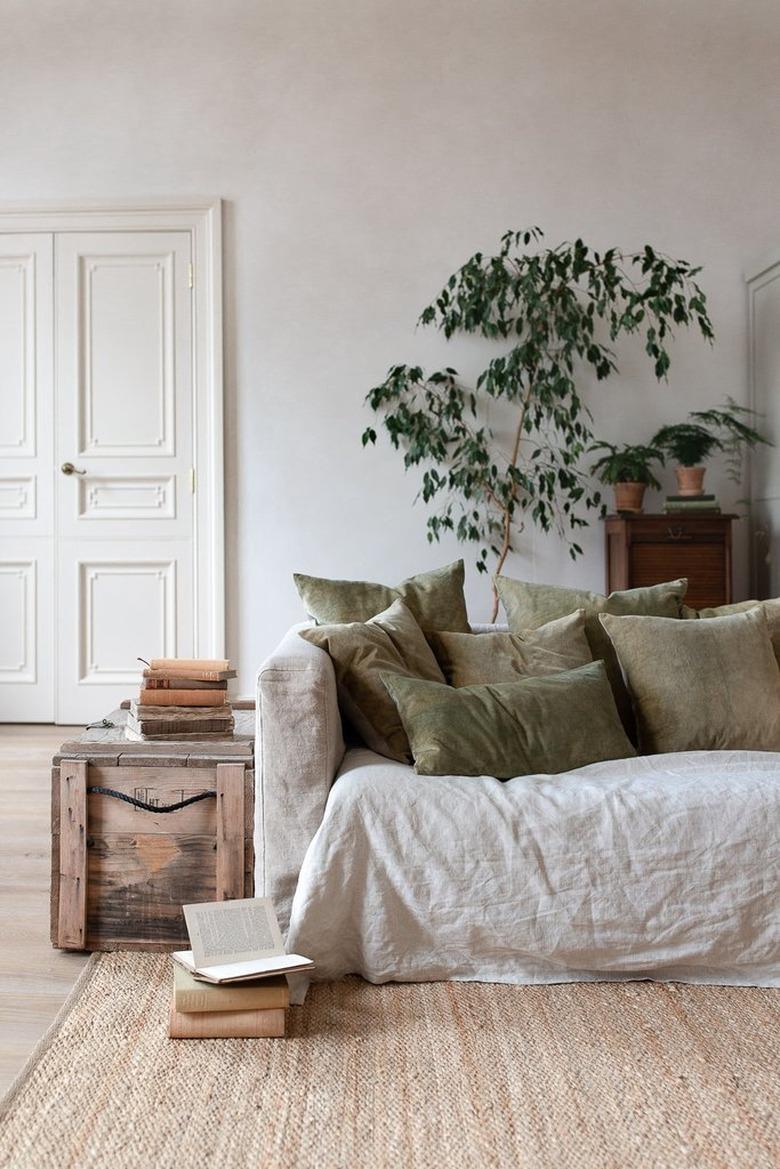 natural decor in a gray room with linen sofa and green pillows