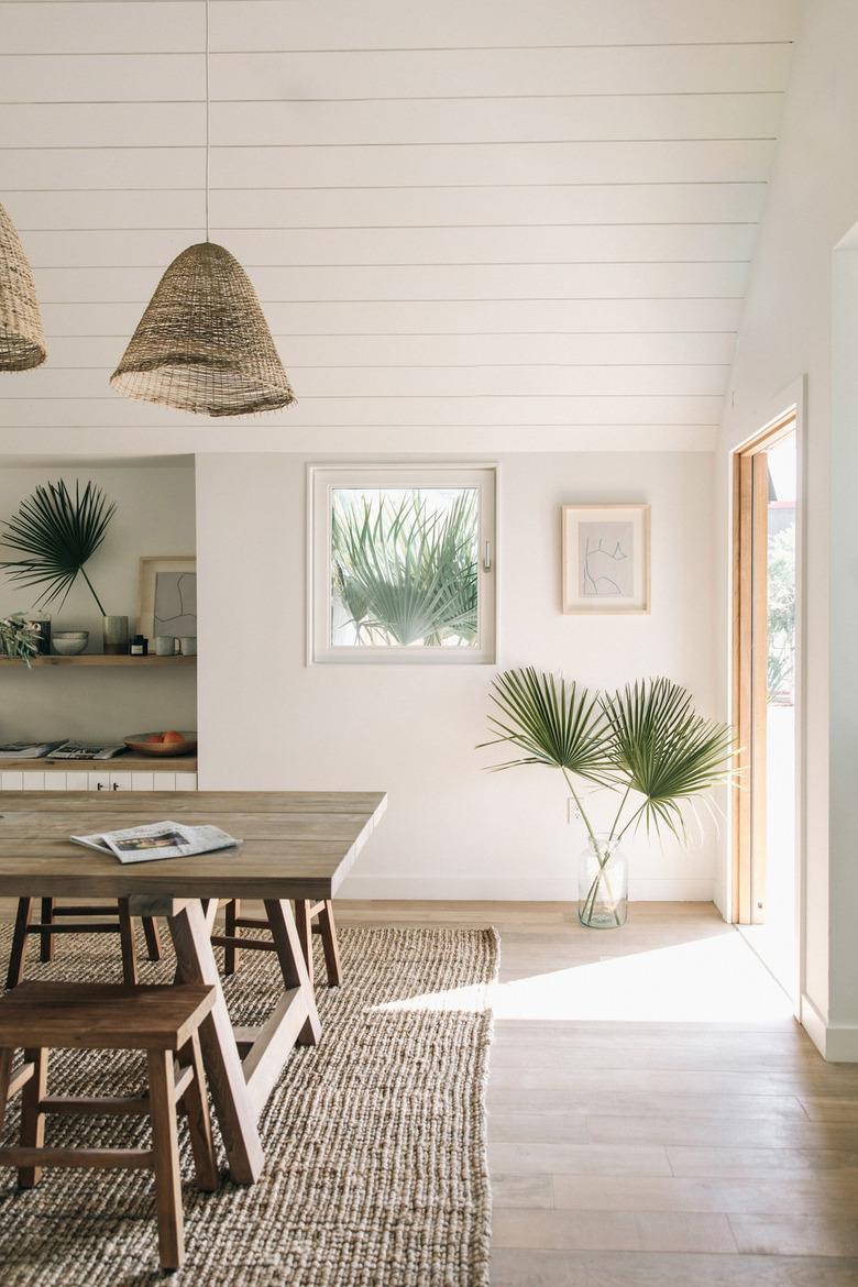 natural decor in white dining room with palms in a vase