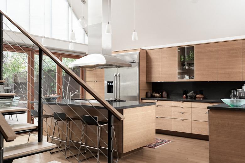 Oak cabinets in modern kitchen with high ceiling