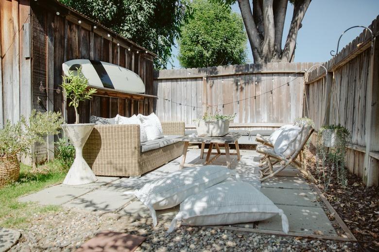 outdoor party idea with floor cushions and string lights around sofa and chairs