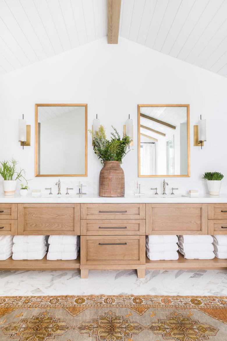 bathroom towel storage idea in A-frame house with exposed wood beam and matching wood vanity cabinet